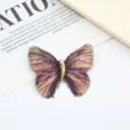 Close-up detail of a gradient embroidered butterfly brooch featuring a shiny metallic gold body. - Rainbow / 5.7x4.5cm