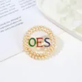 Detailed view of alloy round pearl brooch pin with OES colorful letters for women. - Style 5 OES Colored Enamel Round Style / 4.5*4.5*1cm