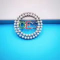 Circular double-layer pearl alloy brooch pin featuring colorful enamel OES letters. - Style 12 OES Silver Base Colored Enamel Style
