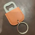 Detail shot of stainless steel bottle opener keychain with orange PU leather sleeve bar tool. - Yellow Brown