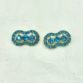Exquisite rhinestone peanut brooch detail featuring brilliant blue crystals set in gold alloy metal. - Sky Blue