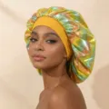 Close-up detail view of holographic satin sleeping cap with wide yellow band, hair care item. - One Size / Yellow