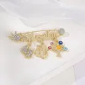 Gold alloy evil eye brooch detail with Masallah text and rhinestones for unique retro style. - Tree of Life Safety Pin