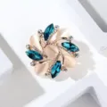 Detailed close-up of exquisite alloy rhinestone brooch with blue crystals and white petals. - Peacock Blue Opal