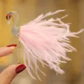 Exquisite flamingo brooch detail featuring sparkling rhinestones, gold tone and soft pink feathers. - Pink