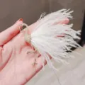 Elegant gold flamingo brooch with soft white feathers, stunning fashion accessory for women. - White