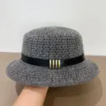 Close-up detail of grey crochet bucket hat featuring black leather belt and metal bars. - M (56-58cm) / Gray