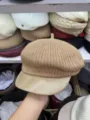 Khaki knitted newsboy hat detail showing textured woolen fabric and smooth leather-like brim. - Camel