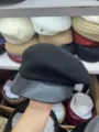 Nahaufnahme Detail einer stilvollen schwarzen Strickbarette mit klassischem Lederschirm. - Schwarz