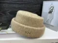 Winter knitted bucket hat with chic metal letter embellishment, warm and stylish detail view. - Camel
