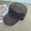 Brown suede flat-top military cap detail showcasing metal rivets and textured fabric design. - Coffee