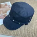 Black faux suede cadet cap detail featuring stylish metal studs and side eyelets for women. - Black