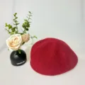 Detailaufnahme einer stilvollen roten Strickbaret mit weicher Textur und feinem, gemütlichem Design. - Rot