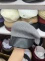 Graue Strick-Barette im Detail, mit stylischem schwarzem Lederkrempe und weicher Wolle. - Grau