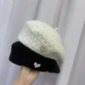 Detailansicht der Perl-Herz-Baretthüte mit schwarzen und weißen Winter-Strickmützen. - Weiß