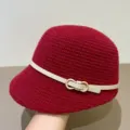 Detailed shot of a red knitted cloche hat with a white belt and metal ring buckle. - M (56-58cm) / Burgundy