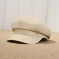 Detalle de primer plano de gorra de vendedor de periódicos de cuero PU beige con chapa metal. - Ajustable / Blanco Roto
