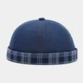 Detail view of the stylish denim docker cap featuring a contrasting blue plaid rolled brim. - Adjustable / Blue
