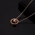 Detailed shot of a stylish rose gold double ring pendant necklace made of durable titanium steel. - Screw Double Ring Layered Style / Rose Gold