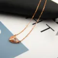 Detailed shot of a rose gold titanium steel heart and key necklace with sparkling zircon pendant. - Heart Key Lock Style / Rose Gold