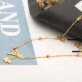 Goldfarbene Ketten-Detailansicht mit einem Love-Buchstaben-Anhänger und feinen Perlen. - LOVE Buchstaben Langer Stil / Gold