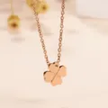 Nahaufnahme des roségoldenen vierblättrigen Kleeblatt Anhänger Halskette mit glitzerndem Stein. - Einzelner Diamant Klee Stil / Roségold