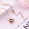 Close-up view of the rose gold titanium steel necklace with black diamond pendant detail. - Double Ring Black Cylinder Style / Rose Gold
