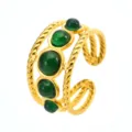 Detail view of a luxury gold stainless steel ring featuring green round resin stones and cable band. - Green