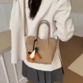 Borsa a secchiello casual in stile coreano con ciondolo a forma di cavallo alato per donna. - Color Tè al Latte Con Ciondolo
