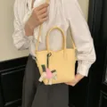 Borsa a tracolla in pelle gialla da donna, elegante borsa casual con ciondolo decorativo. - Giallo Chiaro Con Ciondolo