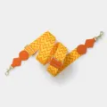 Detailed view of the orange and yellow zig-zag adjustable replacement bag strap. - Orange