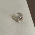 Gedetailleerde close-up van de elegante open ring met parelcluster en prachtige gouden stenen. - Kleine Parelring