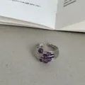 Close-up van een stijlvolle zilverkleurige ring met meerdere strengen en paarse natuurstenen. - Meerlaags Draadgewikkeld / Paars
