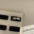 Detailopname van een minimalistische zilveren kruisring bezet met sprankelende zirkonia. - Kruis Gelaagde Stijl (R-1222)