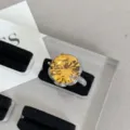 Detailed close-up of a luxury yellow crystal cocktail ring with pave halo in silver finish. - Round Large Rhinestone / Yellow