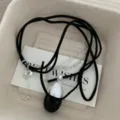 Vista dettagliata della collana unica in corda di velluto nero e catena in argento con ciondolo. - Nero Ovale