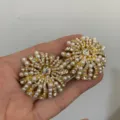 Gouden vintage parel strass starburst oren detail close-up elegante statement sieraden stukken - Vuurwerk Glinstering
