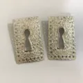 Detailed view of retro silver metallic keyhole earrings with textured finish and perforated border. - Earrings / Silver