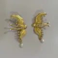 Gedetailleerd overzicht van unieke gouden oorbellen met strasssteentjes en parels. - Vliegende Vogel-4214