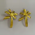 Gedetailleerde close-up van gouden metalen bloem oorbellen, opvallend en stijlvol damesontwerp. - Bloem-4291