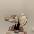 Nahaufnahme des handgefertigten Ozean-Rings mit Naturmuscheln Perlen und Golddraht. - Stil B