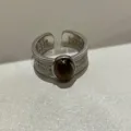 Zilverkleurige open ring met opengewerkt filigraan patroon en ovale donkere imitatiesteen. - Imitatie Tijgeroog Model / Zilver