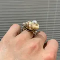 Gros plan détaillé de la bague artisanale de style marin en coquillage naturel et perle au doigt. - Bague Perle Conque (R1045-E)