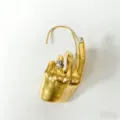 Dettaglio cuffia auricolare in metallo dorato con anello unico e cristallo brillante. - Oro