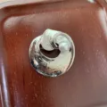 Gedetailleerde close-up van de chique asymmetrische metalen parelbroche met textuur. - Spiraal Stijl / Zilver