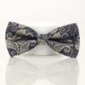 Close-up of a navy blue bow tie with exquisite gold and white paisley jacquard pattern. - Elegant Grey Paisley Bowtie