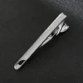 Close-up view of a sleek silver metal tie clip, showcasing smooth polish and clasp detail. - Style 09