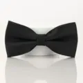 Gros plan détail du nœud papillon noir classique montrant un tissu texturé et un nœud. - Nœud papillon noir à texture fine