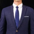 Detailansicht eines Herren-Businessanzugs mit weißem Hemd und blau gestreifter Krawatte. - Stil 019
