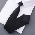 Close-up view of an elegant black textured business necktie displayed on a clean white shirt. - Style 010